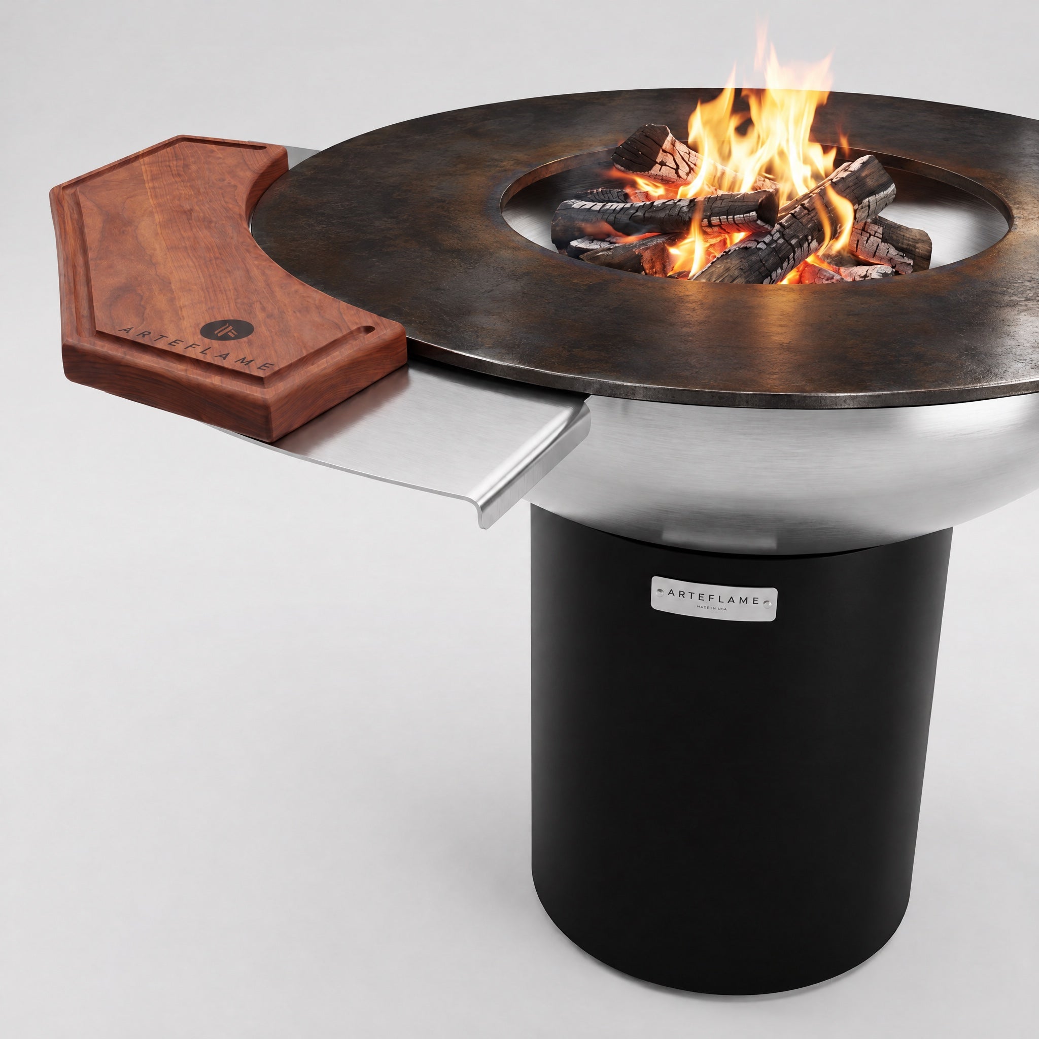 Arteflame rosewood cutting board on the side table of a 40″ stainless steel grill with a black base and wood fire